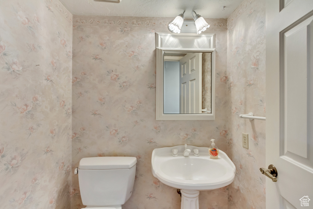 Bathroom with sink, toilet, and a textured ceiling