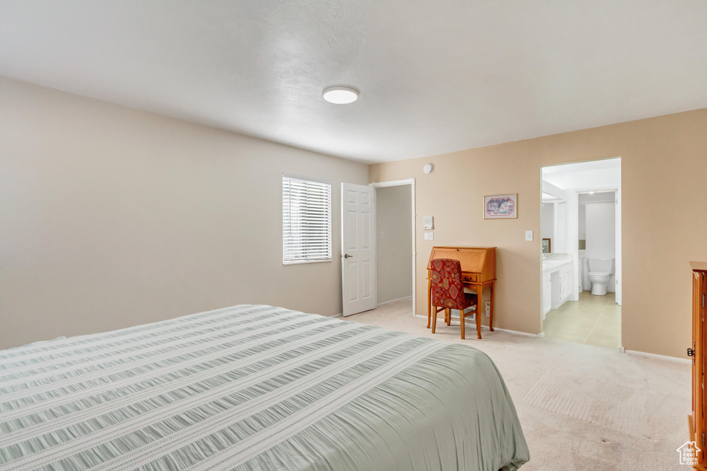 Carpeted bedroom featuring ensuite bath