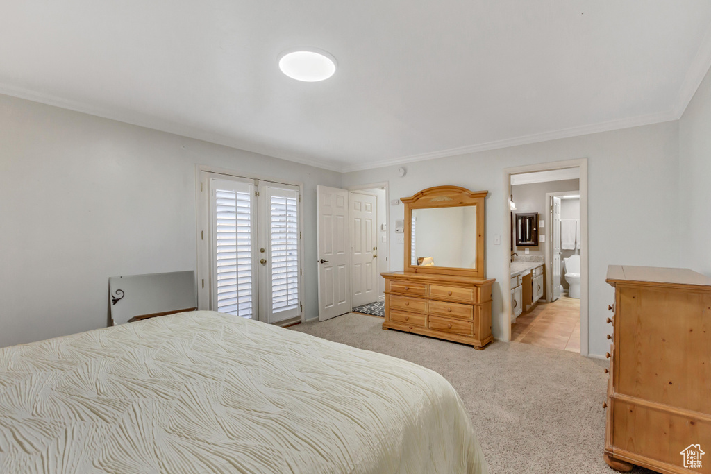 Carpeted bedroom featuring crown molding, access to outside, and ensuite bathroom