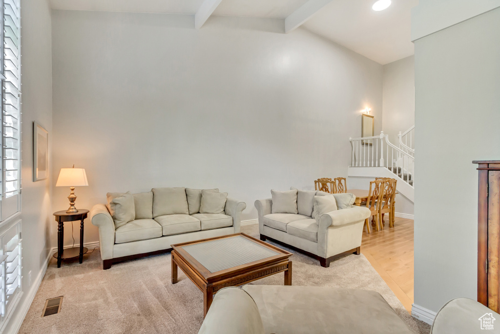 Living room featuring hardwood / wood-style flooring and vaulted ceiling with beams