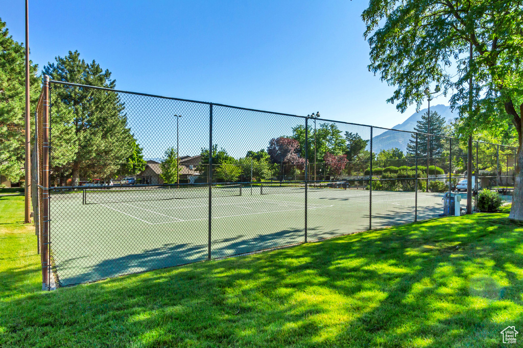 View of tennis court with a lawn