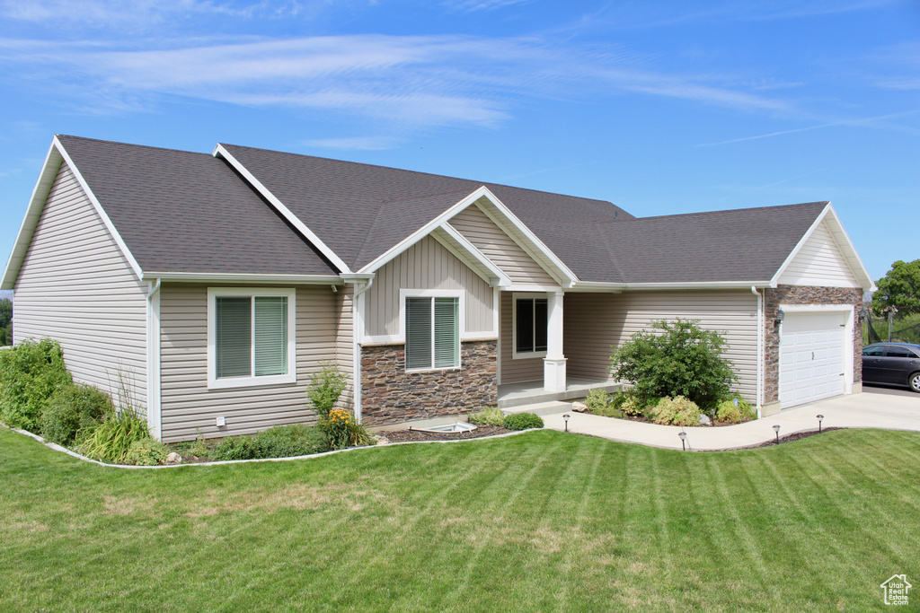 View of front of house featuring a garage and a front yard