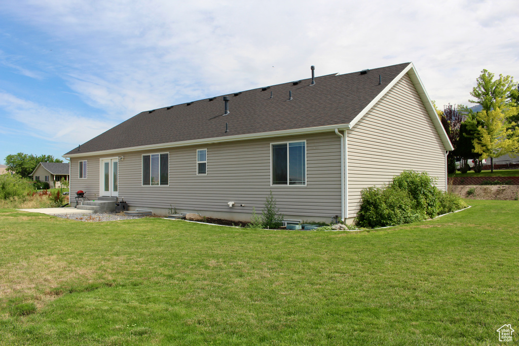 Rear view of house featuring a patio area and a yard