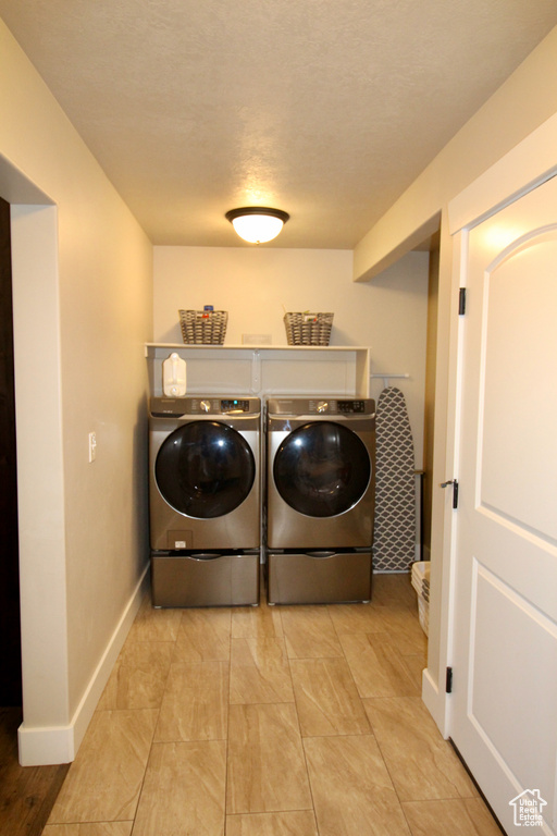 Laundry room featuring washing machine and clothes dryer and light tile patterned floors