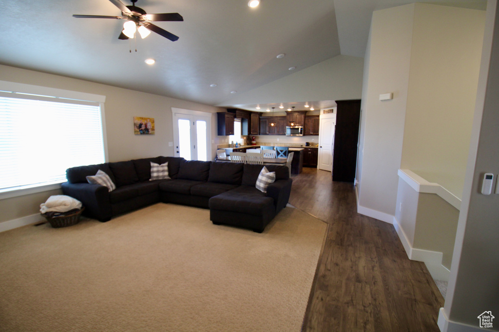 Living room featuring lofted ceiling, dark wood-type flooring, and ceiling fan