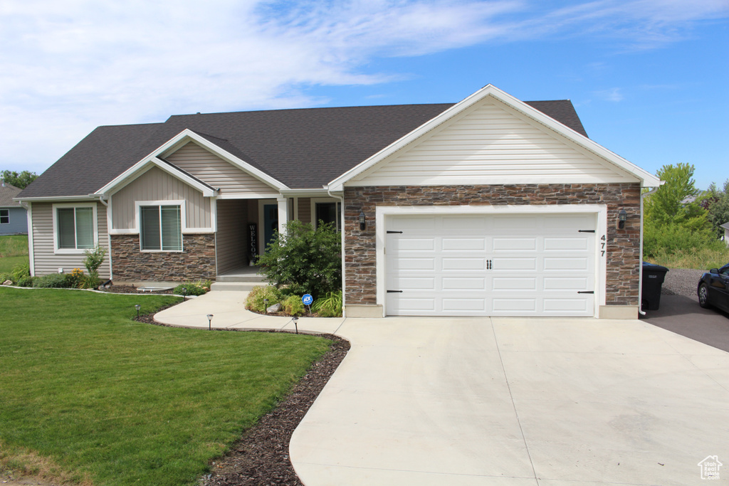 View of front of property featuring a garage and a front yard