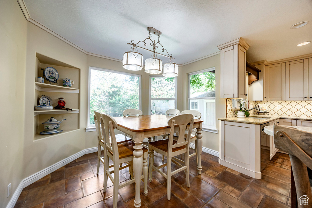 Tiled dining room featuring sink and ornamental molding