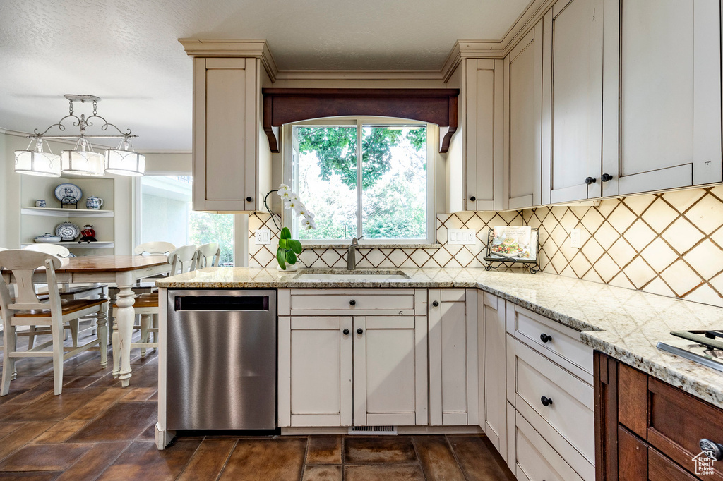 Kitchen with dishwasher, tasteful backsplash, sink, dark tile patterned flooring, and light stone countertops