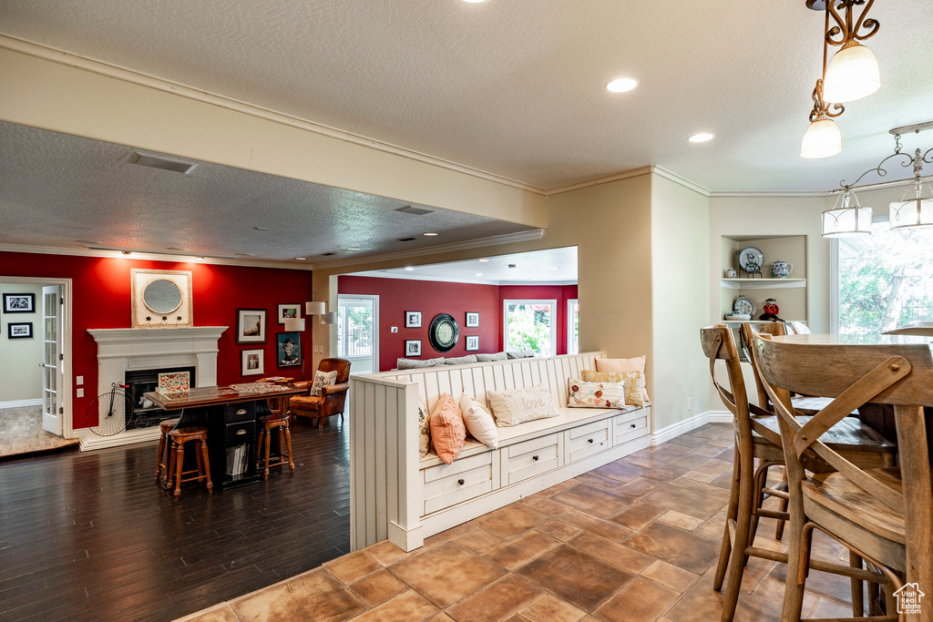 Dining space featuring a textured ceiling, ornamental molding, and dark hardwood / wood-style floors