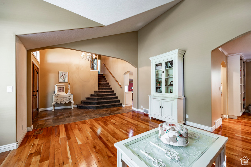 Unfurnished living room with hardwood / wood-style flooring and high vaulted ceiling