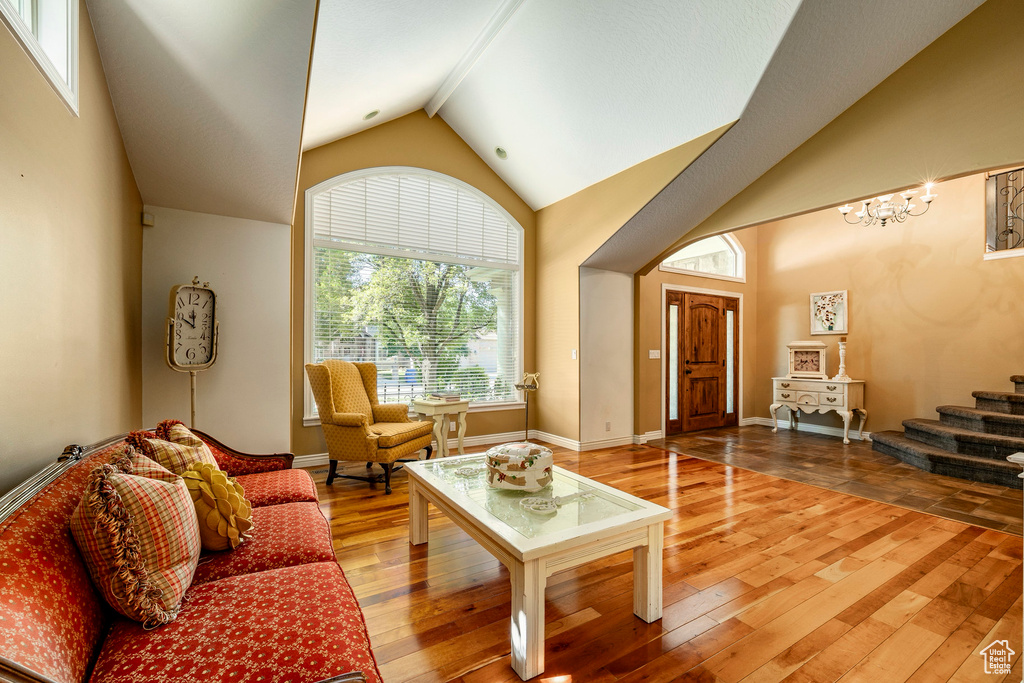 Living room featuring high vaulted ceiling and light hardwood / wood-style flooring