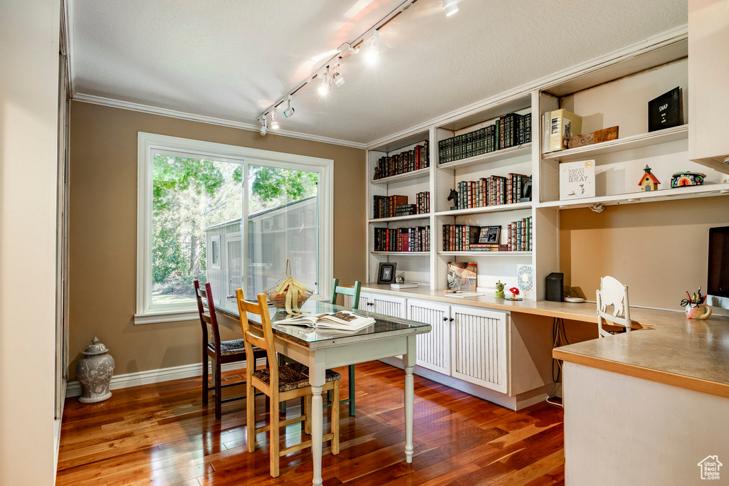 Office area with hardwood / wood-style floors, ornamental molding, and track lighting