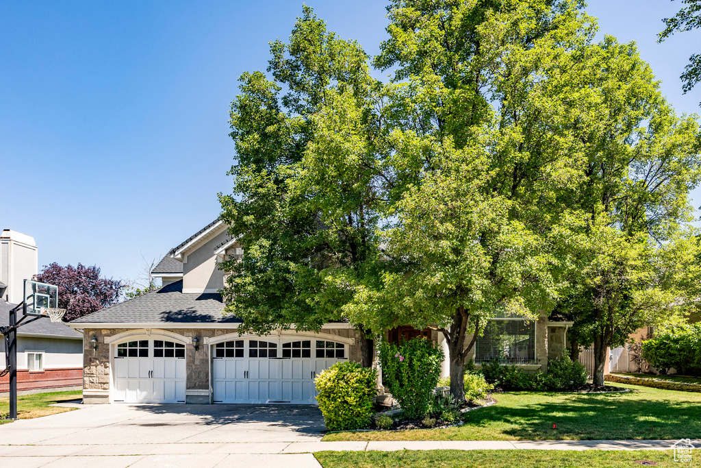 View of front of home with a garage and a front lawn