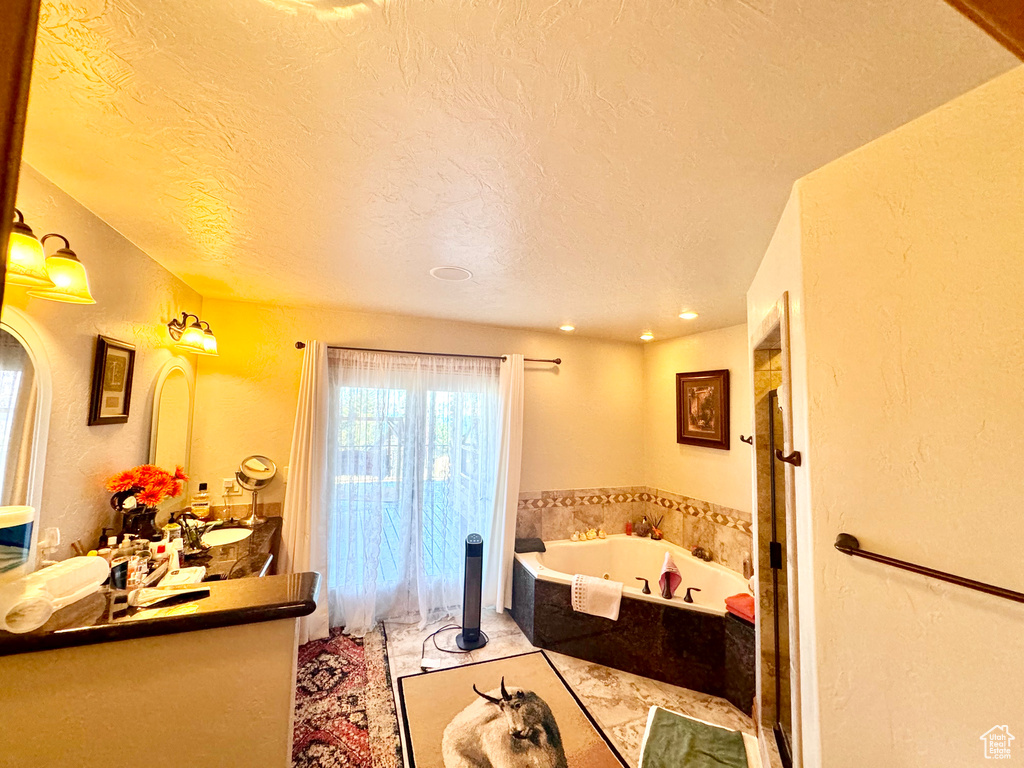 Bathroom featuring vanity, a textured ceiling, and a bathtub