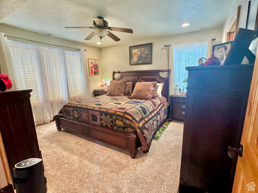 Bedroom featuring carpet floors, a textured ceiling, and ceiling fan