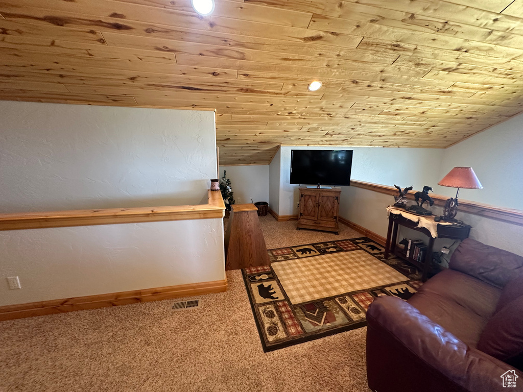 Carpeted living room with vaulted ceiling and wooden ceiling