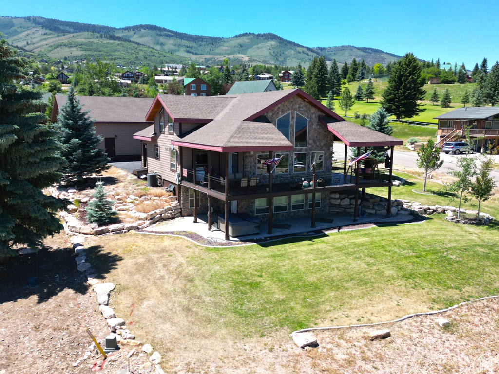 Back of house with a mountain view, a patio area, a gazebo, and a yard