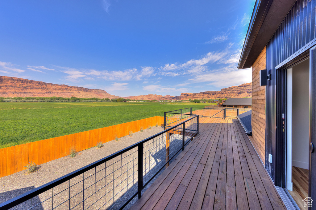 Wooden deck featuring a yard, a rural view, and a mountain view