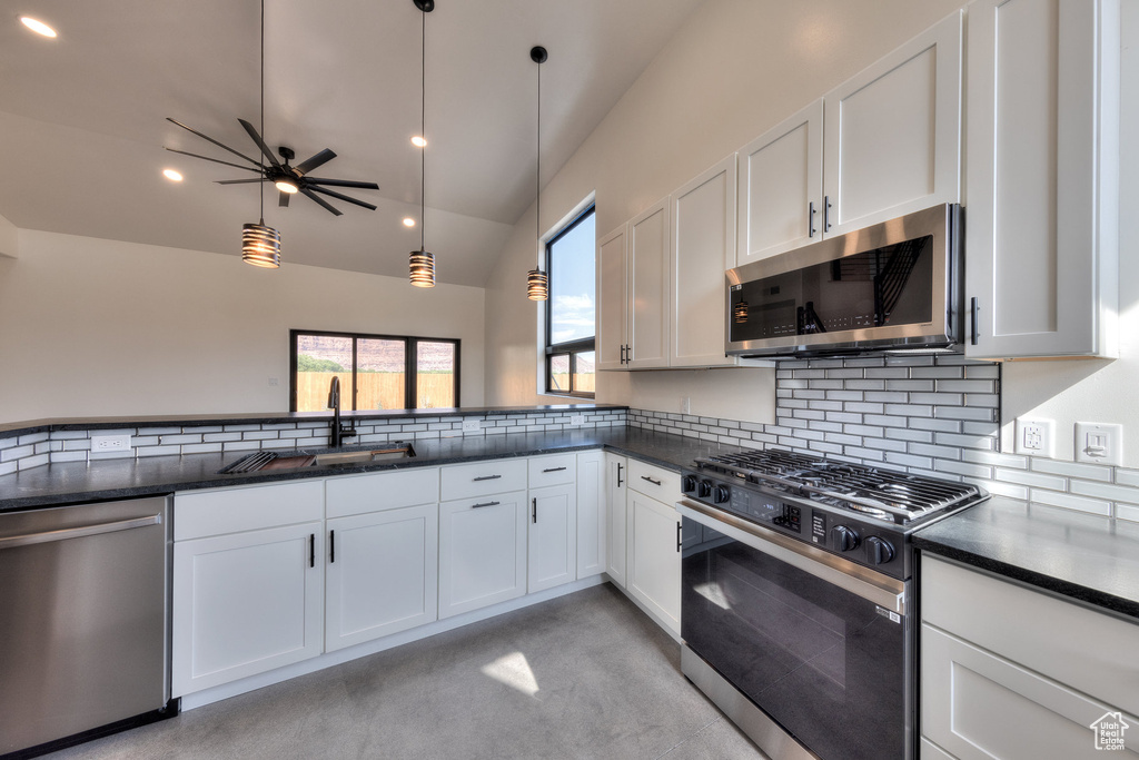 Kitchen featuring pendant lighting, white cabinetry, sink, ceiling fan, and appliances with stainless steel finishes