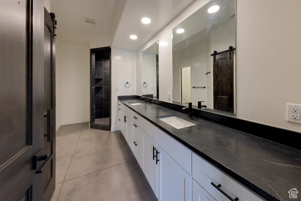 Bathroom featuring walk in shower, concrete floors, and vanity