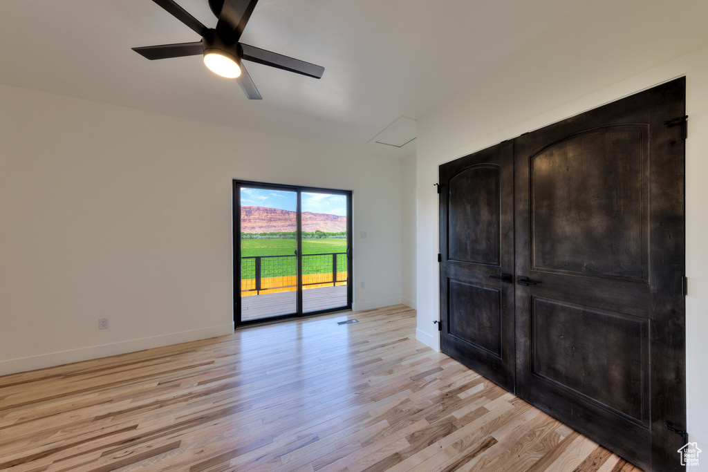 Unfurnished bedroom featuring light hardwood / wood-style flooring, access to exterior, and ceiling fan