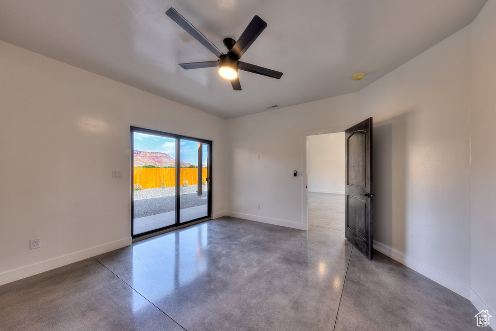 Unfurnished room with concrete flooring and ceiling fan