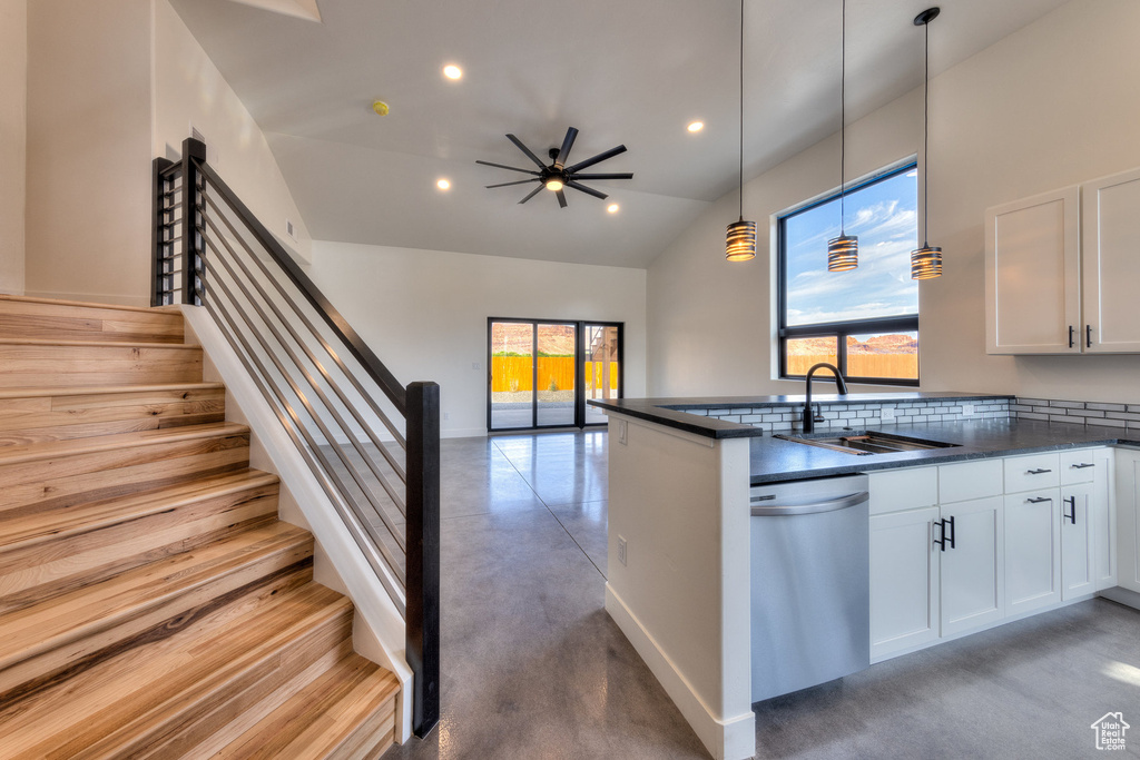 Kitchen featuring white cabinets, decorative light fixtures, sink, kitchen peninsula, and stainless steel dishwasher