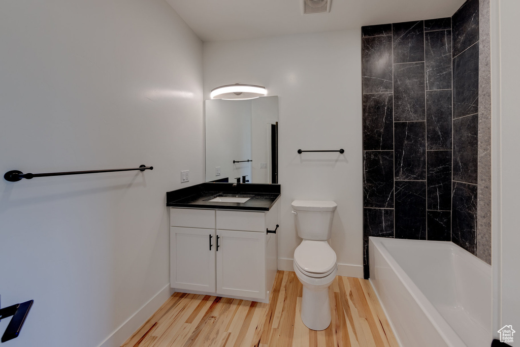 Bathroom with vanity, toilet, and hardwood / wood-style flooring