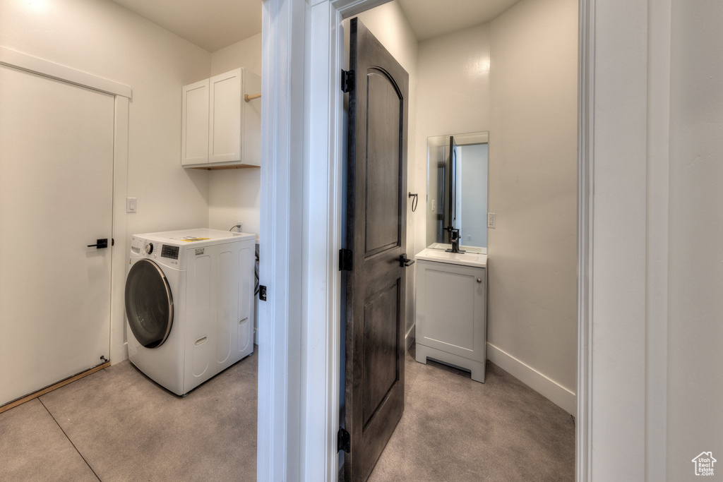 Washroom featuring sink, light colored carpet, and washer / clothes dryer