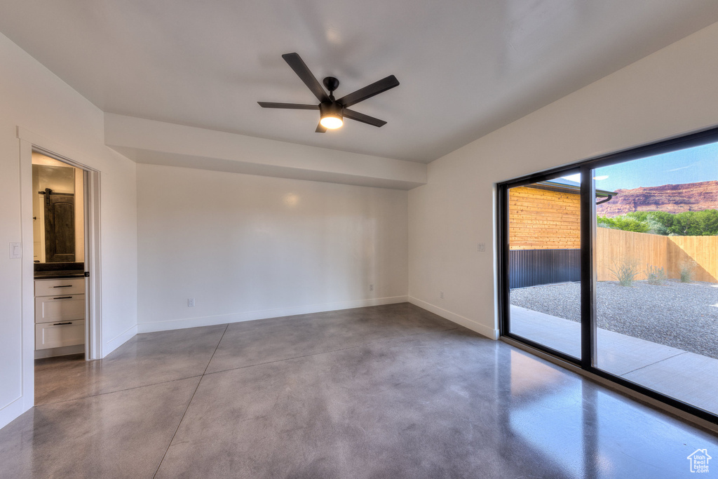 Spare room featuring ceiling fan and concrete flooring