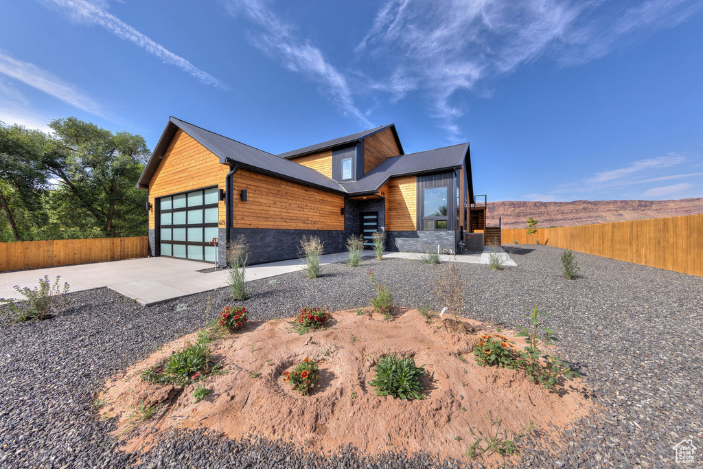 Contemporary house featuring cooling unit and a garage