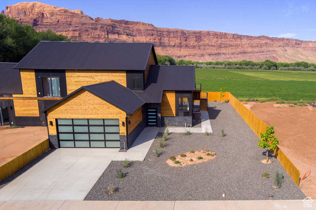 View of front of house with a mountain view, a garage, and a front lawn