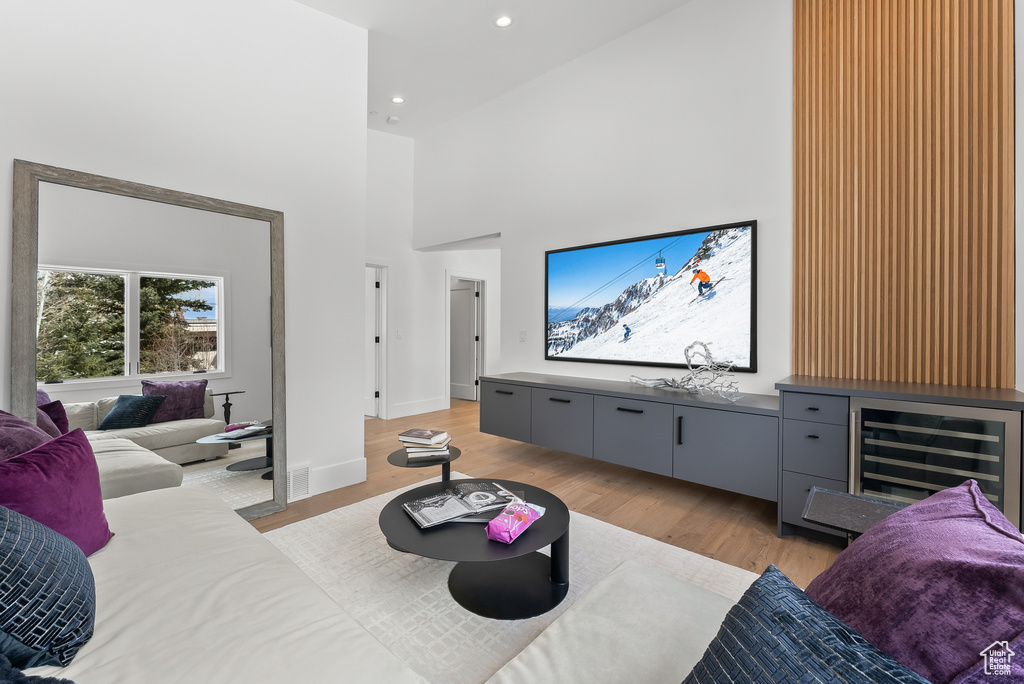 Living room featuring light hardwood / wood-style floors and a high ceiling