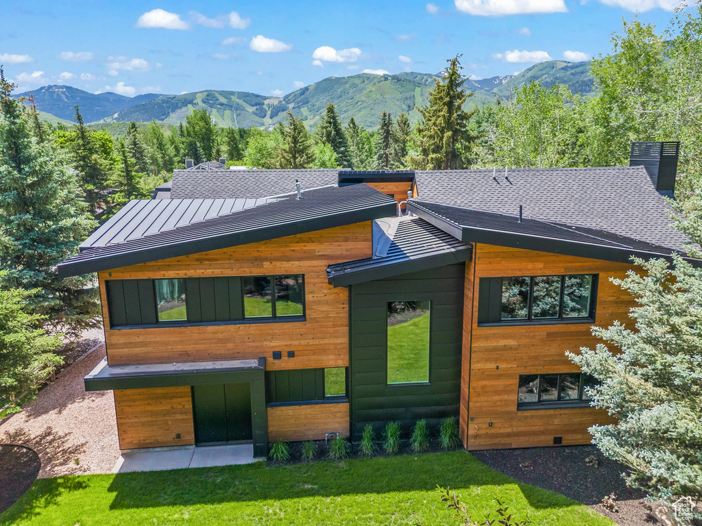 View of front of home with a mountain view and a front lawn