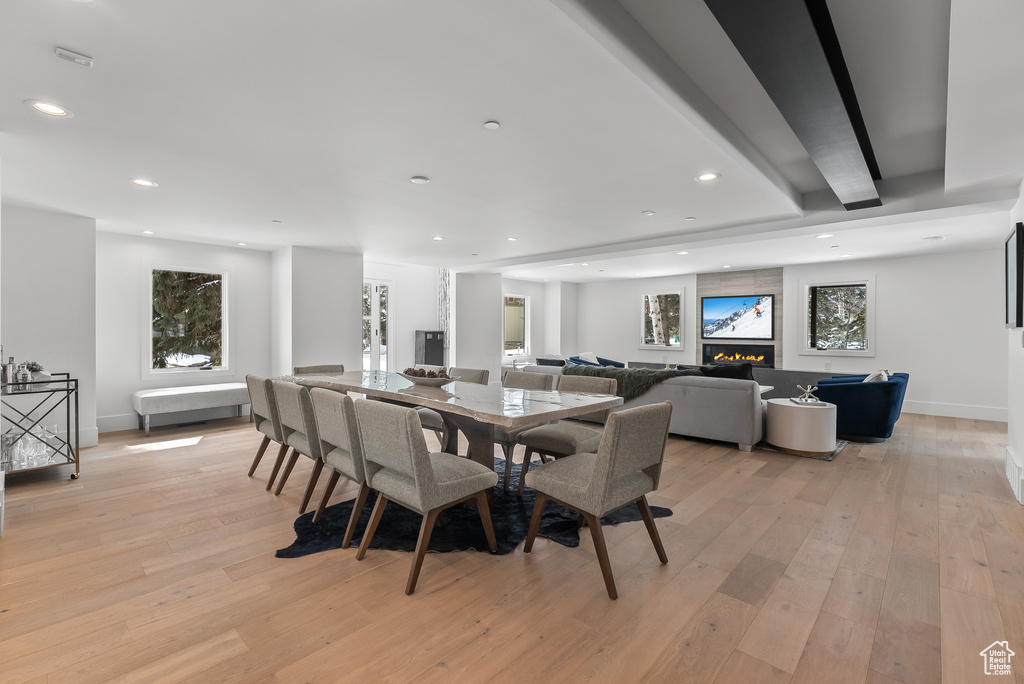 Dining area with beamed ceiling and light wood-type flooring