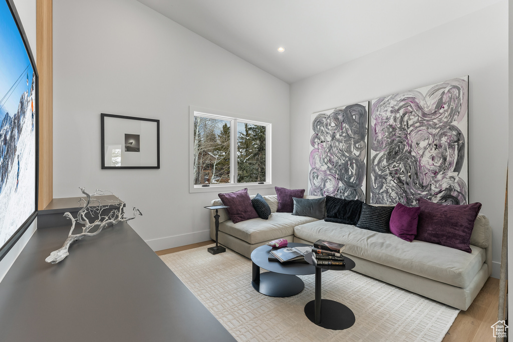 Living room featuring lofted ceiling and light hardwood / wood-style floors