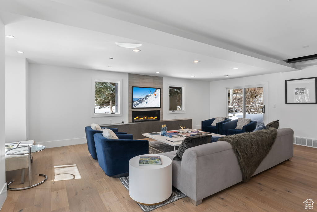 Living room featuring light hardwood / wood-style flooring, a high end fireplace, and plenty of natural light