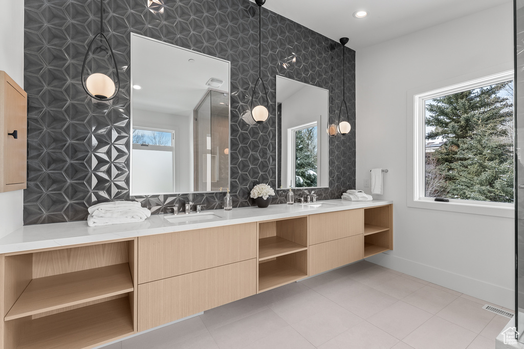 Bathroom featuring plenty of natural light, tile patterned flooring, and dual vanity