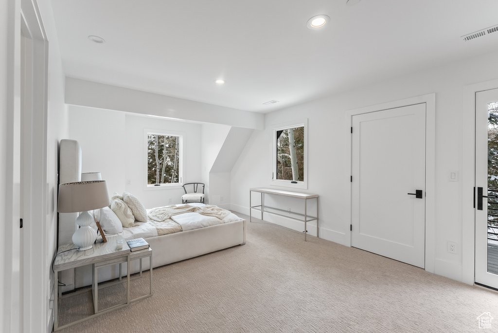 Bedroom featuring light carpet, multiple windows, and access to outside