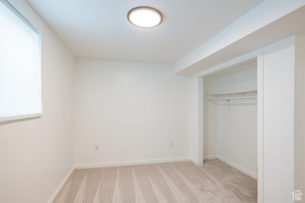 Unfurnished bedroom with light carpet and a closet