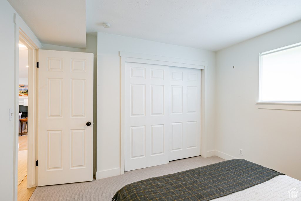 Bedroom featuring light carpet and a closet