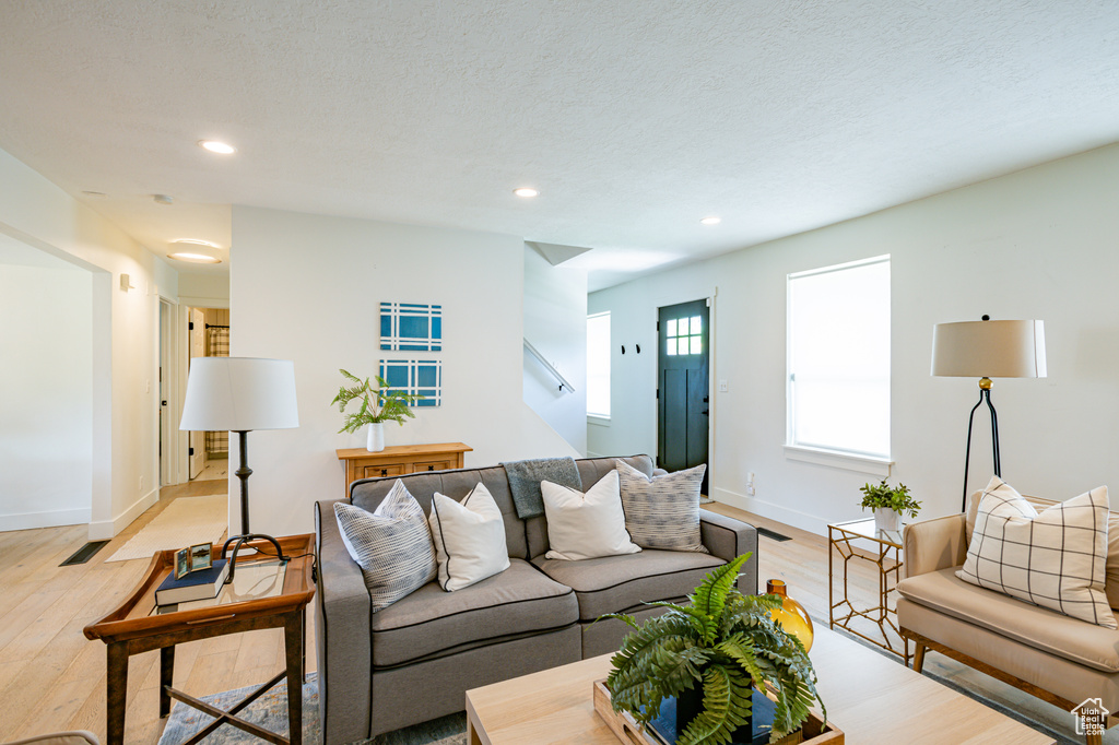 Living room with light hardwood / wood-style floors and a textured ceiling