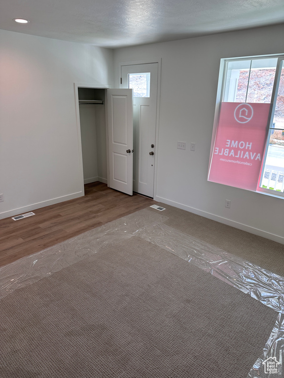 Interior space with a textured ceiling and hardwood / wood-style flooring