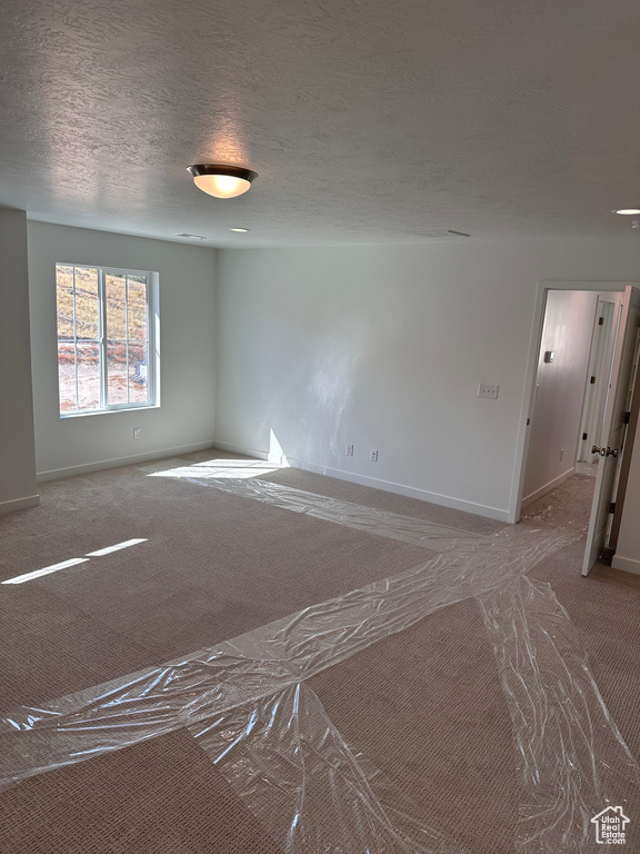 Spare room with a textured ceiling and carpet