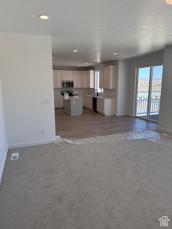 Kitchen featuring a textured ceiling, light hardwood / wood-style floors, white cabinetry, and dishwasher