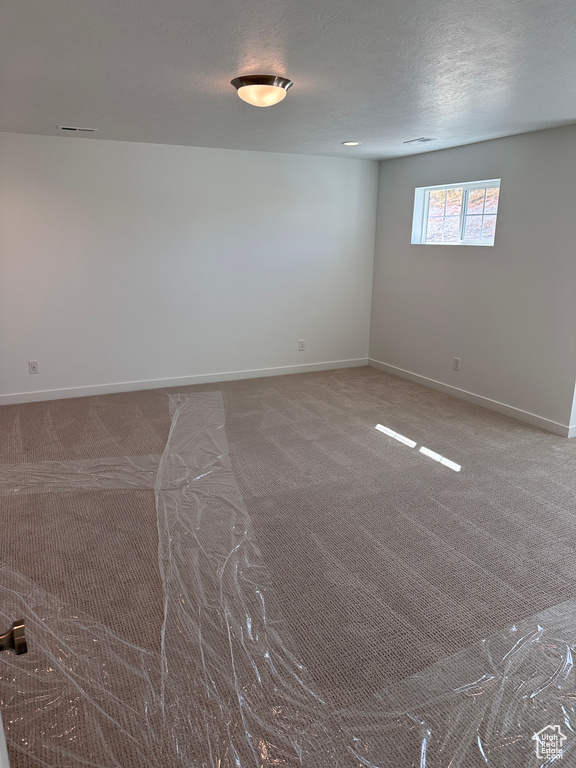 Carpeted spare room with a textured ceiling