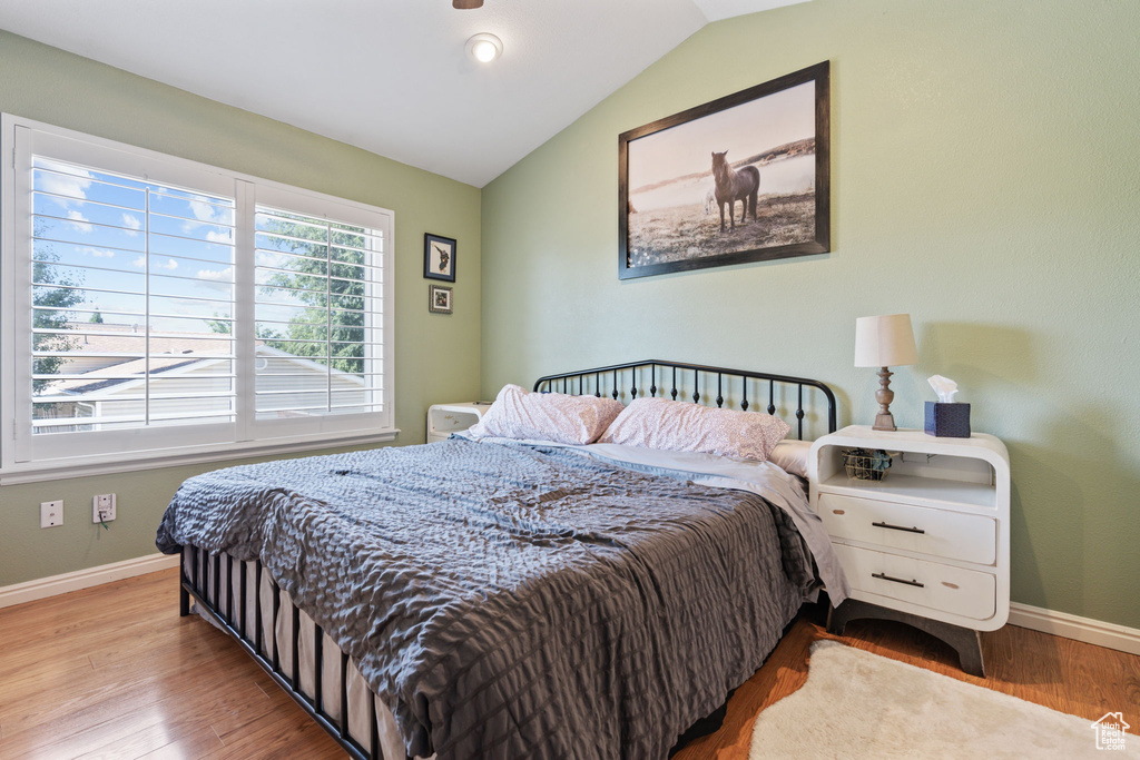 Bedroom featuring light hardwood / wood-style floors and vaulted ceiling