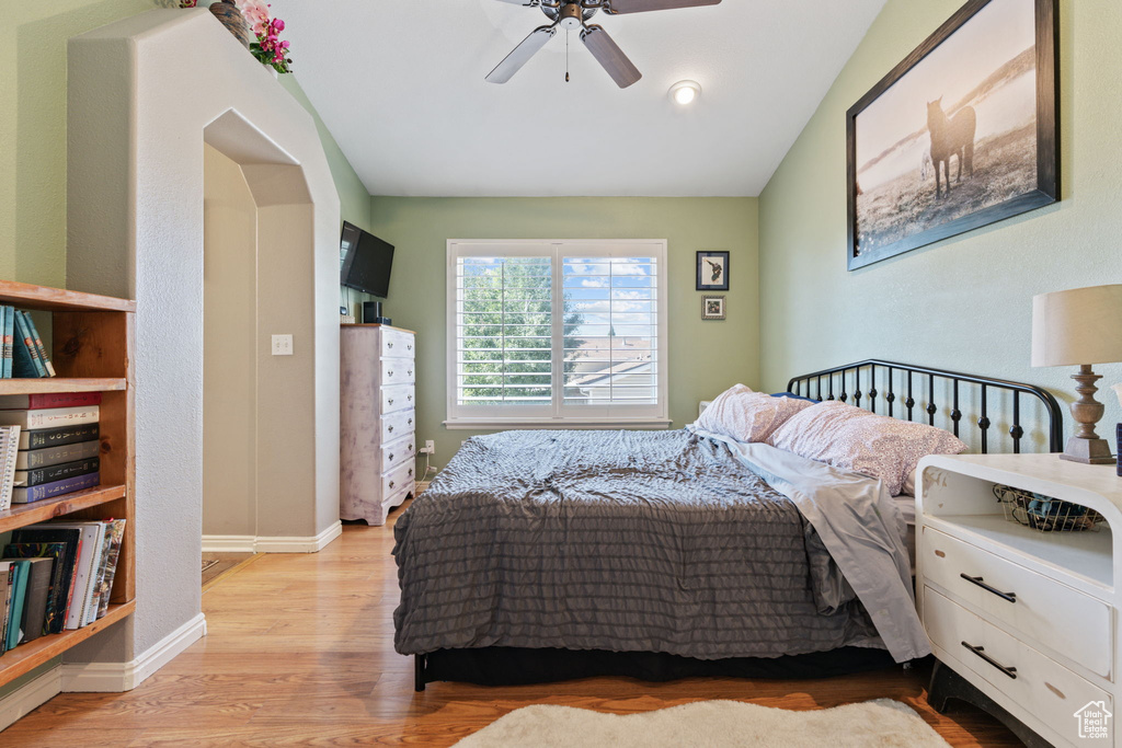 Bedroom with vaulted ceiling, ceiling fan, and light wood-type flooring