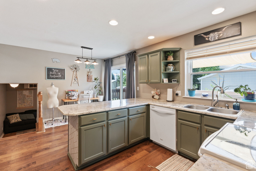 Kitchen with hanging light fixtures, sink, dishwasher, and dark wood-type flooring