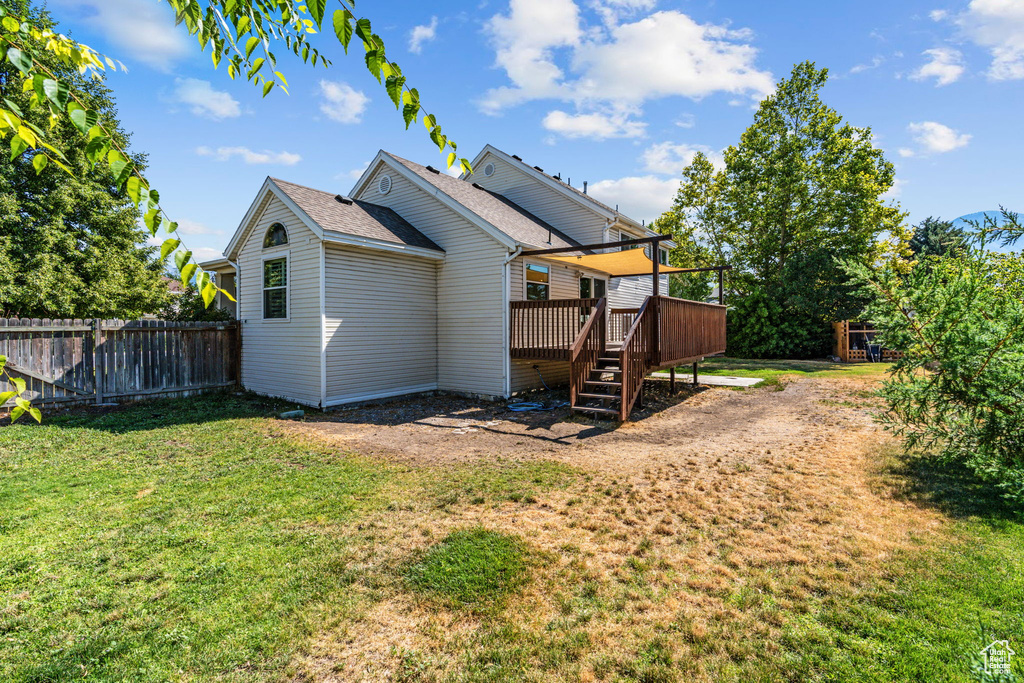 Back of house featuring a deck and a yard